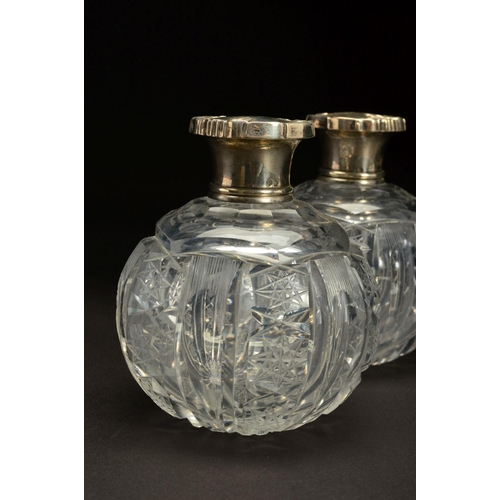 153 - A PAIR OF EARLY 20TH CENTURY SPHERICAL GLASS SCENT BOTTLES, with white metal pull off covers stamped... 