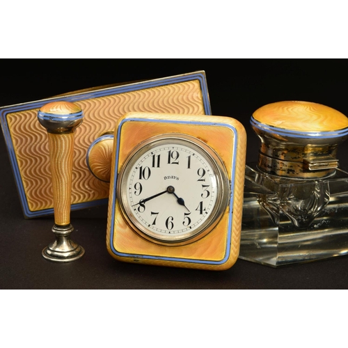 167 - A GEORGE V SILVER AND APRICOT ENAMEL DESK SET, comprising rectangular easel back desk clock, seal, g... 