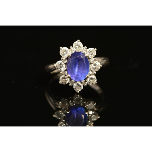 2 - A MODERN 18CT WHITE GOLD TANZANITE AND DIAMOND OVAL CLUSTER RING, oval mixed cut tanzanite measuring... 