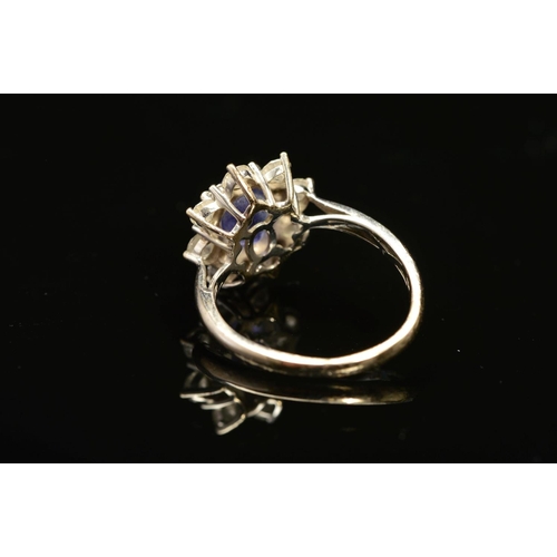 2 - A MODERN 18CT WHITE GOLD TANZANITE AND DIAMOND OVAL CLUSTER RING, oval mixed cut tanzanite measuring... 