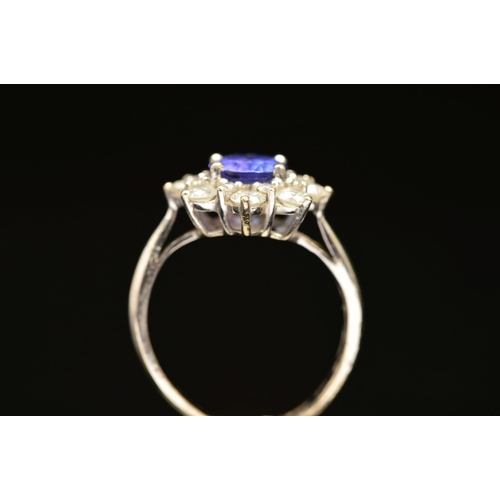 2 - A MODERN 18CT WHITE GOLD TANZANITE AND DIAMOND OVAL CLUSTER RING, oval mixed cut tanzanite measuring... 