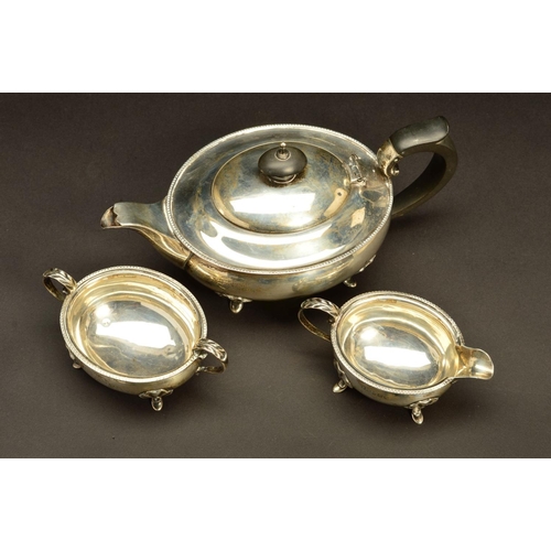 202 - A GEORGE V SILVER THREE PIECE BACHELOR'S TEASET, of oval form, egg and tongue rims, on four cabriole... 