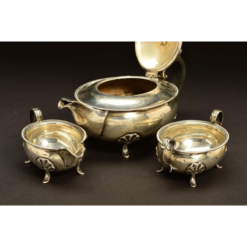 202 - A GEORGE V SILVER THREE PIECE BACHELOR'S TEASET, of oval form, egg and tongue rims, on four cabriole... 