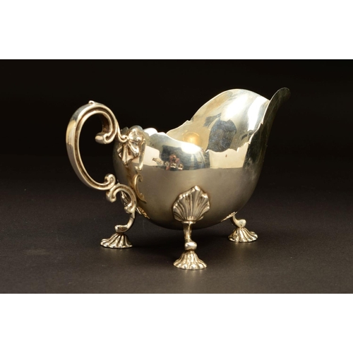 203 - A GEORGE V SILVER SAUCEBOAT BY ASPREY & CO LTD, of oval form with wavy rim, double 'C' scroll handle... 