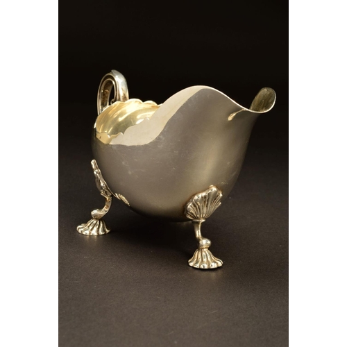 203 - A GEORGE V SILVER SAUCEBOAT BY ASPREY & CO LTD, of oval form with wavy rim, double 'C' scroll handle... 