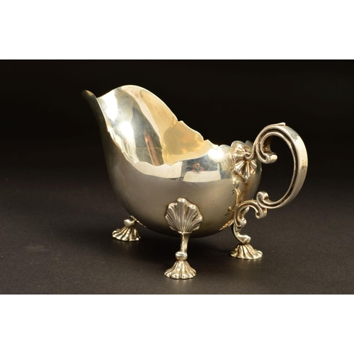 203 - A GEORGE V SILVER SAUCEBOAT BY ASPREY & CO LTD, of oval form with wavy rim, double 'C' scroll handle... 