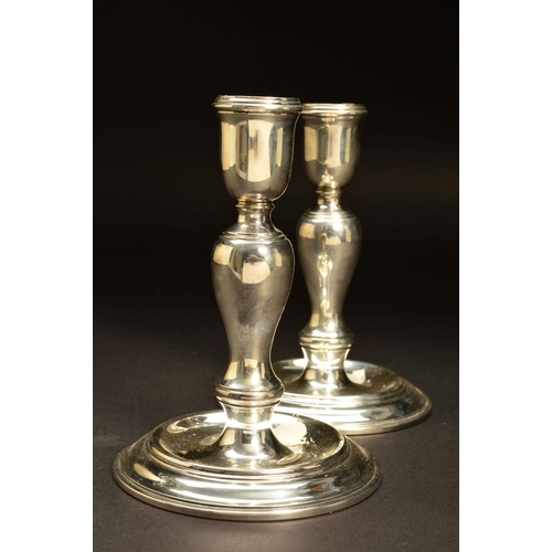 207 - A PAIR OF ELIZABETH II SILVER CANDLESTICKS OF GEORGE I STYLE, urn shaped holders on inverted baluste... 