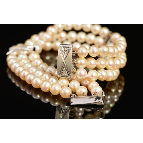 21 - A MODERN 18CT WHITE GOLD, THREE ROW CULTURED PEARL AND DIAMOND BRACELET, each row intersected by a r... 