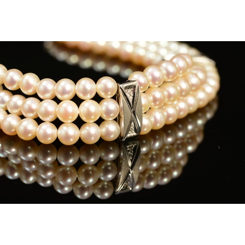 21 - A MODERN 18CT WHITE GOLD, THREE ROW CULTURED PEARL AND DIAMOND BRACELET, each row intersected by a r... 