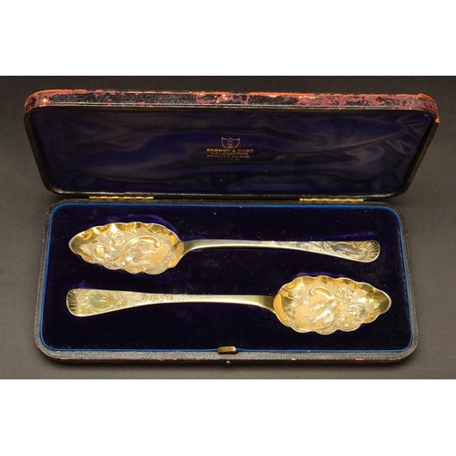 210 - A CASED PAIR OF GEORGE IV SILVER GILT BERRY SPOONS, foliate chased handles engraved with initials 'J... 