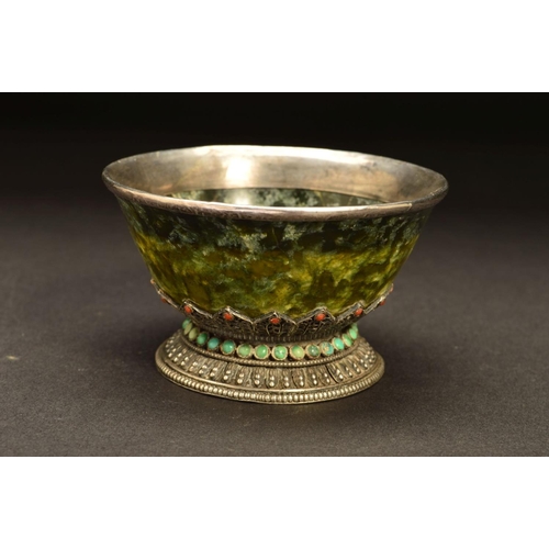 217 - A MIDDLE EASTERN WHITE METAL MOUNTED GREEN STONE BOWL, possibly Connemara marble, the white metal fi... 