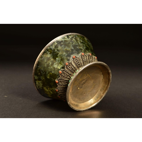 217 - A MIDDLE EASTERN WHITE METAL MOUNTED GREEN STONE BOWL, possibly Connemara marble, the white metal fi... 