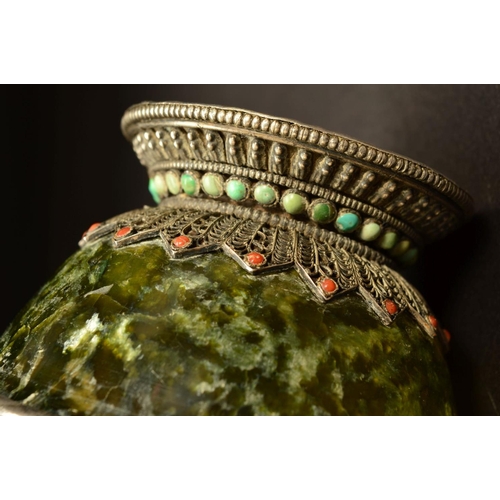 217 - A MIDDLE EASTERN WHITE METAL MOUNTED GREEN STONE BOWL, possibly Connemara marble, the white metal fi... 