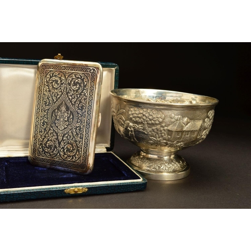 228 - AN INDIAN SILVER PEDESTAL BOWL, embossed with a continuous scene of village life with buildings, cat... 