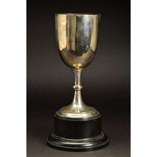 235 - A GEORGE V SILVER TROPHY CUP, plain with knopped stem, mounted on a black plastic socle base, makers... 