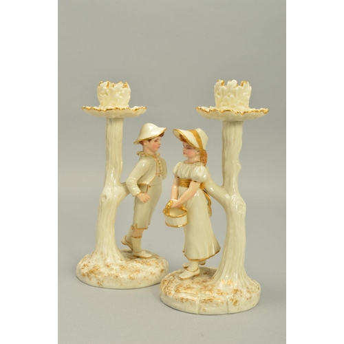 252 - A PAIR OF ROYAL WORCESTER KATE GREENWAY STYLE FIGURAL CANDLESTICKS, modelled by James Hadley, white ... 