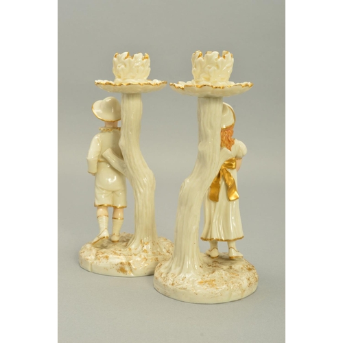 252 - A PAIR OF ROYAL WORCESTER KATE GREENWAY STYLE FIGURAL CANDLESTICKS, modelled by James Hadley, white ... 