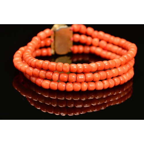 28 - A LATE VICTORIAN THREE ROW CORAL BRACELET, rounded beads strung plain to a three row gilt coral flor... 