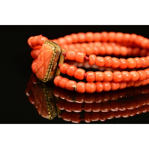 28 - A LATE VICTORIAN THREE ROW CORAL BRACELET, rounded beads strung plain to a three row gilt coral flor... 