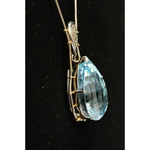 4 - A MODERN 18CT WHITE GOLD LARGE BLUE TOPAZ AND DIAMOND PENDANT, claw set in an abstract mount, topaz ... 