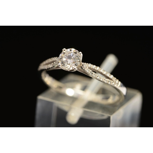 40 - A MODERN DIAMOND SINGLE STONE RING, with diamond crossover set shoulders, principle diamond accompan... 