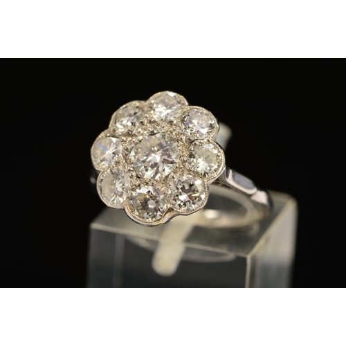 51 - A DIAMOND CLUSTER RING, the central brilliant cut diamond within a surround of eight brilliant cut d... 