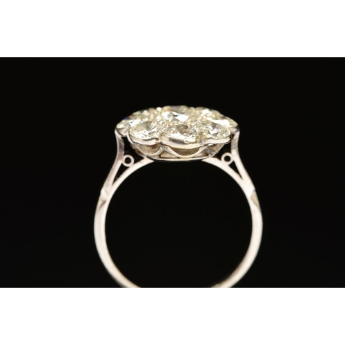 51 - A DIAMOND CLUSTER RING, the central brilliant cut diamond within a surround of eight brilliant cut d... 