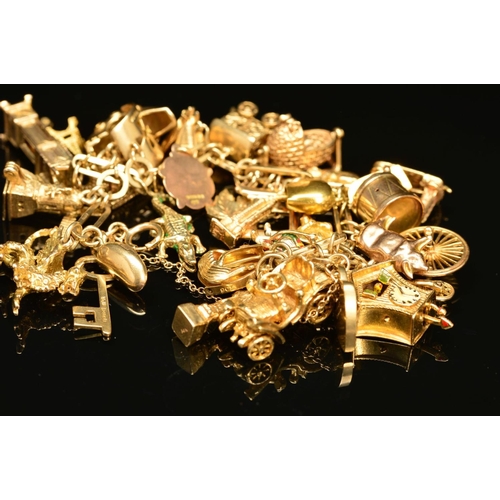 53 - A 9CT GOLD CHARM BRACELET, the fancy link bracelet suspending a total of thirty charms, to include a... 