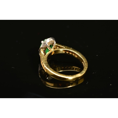 54 - A MODERN 18CT GOLD EMERALD AND DIAMOND HALO CLUSTER STYLE RING, with diamond set shoulders, emerald ... 