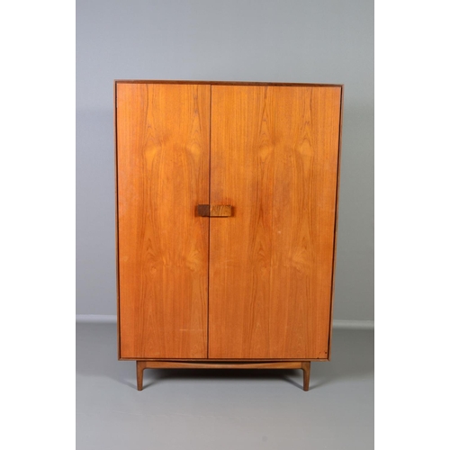 588 - IB KOFOD LARSEN, FOR GPLAN DANISH RANGE, a teak 1960's triple door wardrobe, with double bifold and ... 