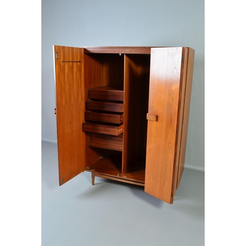 588 - IB KOFOD LARSEN, FOR GPLAN DANISH RANGE, a teak 1960's triple door wardrobe, with double bifold and ... 