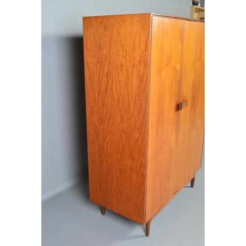 588 - IB KOFOD LARSEN, FOR GPLAN DANISH RANGE, a teak 1960's triple door wardrobe, with double bifold and ... 