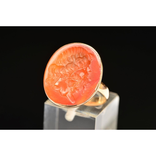 60 - A CARNELIAN INTAGLIO RING, the oval carnelian carved to depict a bearded man, within a collet mount ... 