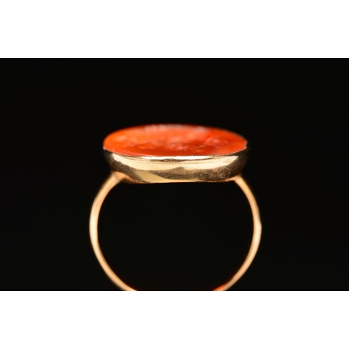 60 - A CARNELIAN INTAGLIO RING, the oval carnelian carved to depict a bearded man, within a collet mount ... 