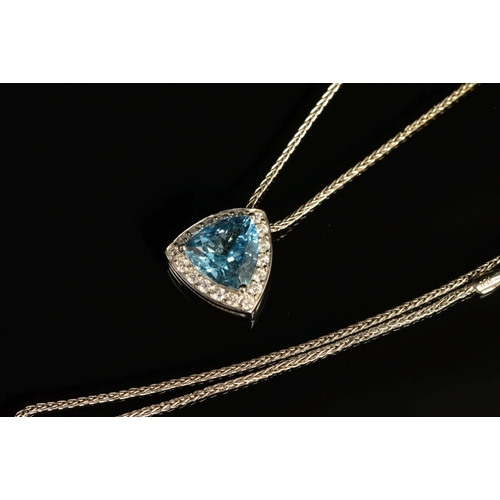 64 - A MODERN 18CT WHITE GOLD AQUAMARINE AND DIAMOND TRIANGULAR SHAPE PENDANT, centring on a principle tr... 