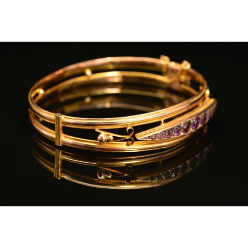 66 - AN EARLY 20TH CENTURY 9CT GOLD AMETHYST AND DIAMOND HINGED BANGLE, designed as a navette shape panel... 