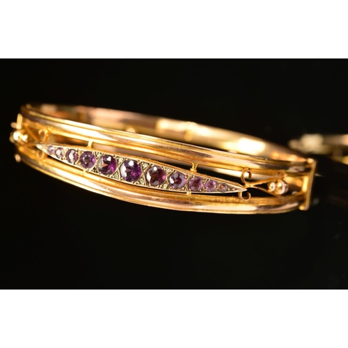 66 - AN EARLY 20TH CENTURY 9CT GOLD AMETHYST AND DIAMOND HINGED BANGLE, designed as a navette shape panel... 