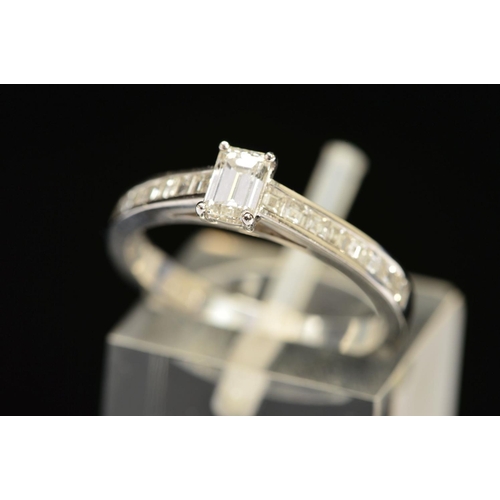 68 - A MODERN EMERALD CUT DIAMOND RING, with square cut diamonds channel set to the shoulders, centre eme... 