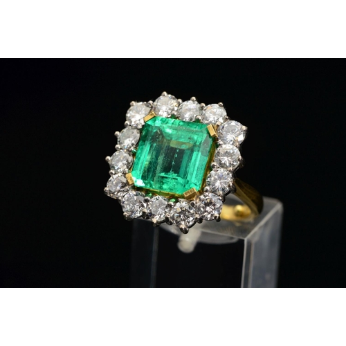 82 - AN IMPRESSIVE 18CT GOLD EMERALD AND DIAMOND CLUSTER RING, centring on an emerald cut emerald measuri... 