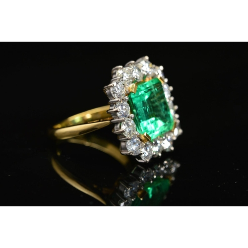 82 - AN IMPRESSIVE 18CT GOLD EMERALD AND DIAMOND CLUSTER RING, centring on an emerald cut emerald measuri... 