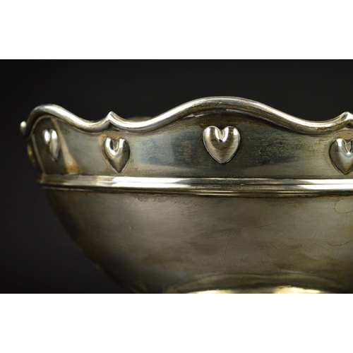 84 - AN EDWARDIAN SILVER ROSE BOWL, the wavy rim above a border of embossed hearts and a raised concentri... 