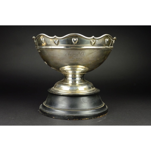 84 - AN EDWARDIAN SILVER ROSE BOWL, the wavy rim above a border of embossed hearts and a raised concentri... 