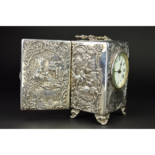 87 - AN EDWARDIAN SILVER CASED BOUDOIR OR CARRIAGE TIMEPIECE, the top with hinged carrying handle cast an... 