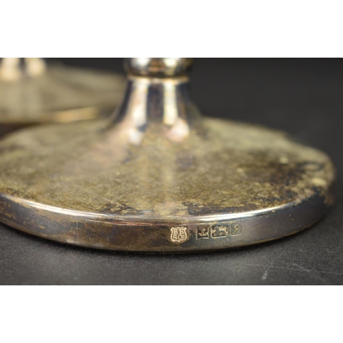 92 - A PAIR OF ELIZABETH II SILVER CANDLESTICKS, circular sconces over tapering stems to a circular loade... 