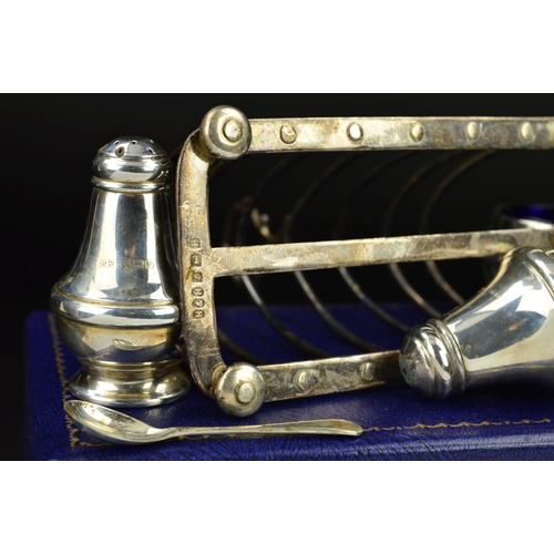 93 - A GEORGE V SILVER SEVEN BAR TOAST RACK, arched form on a rectangular base with flattened bun feet, n... 