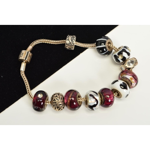 104 - A MODERN RHONA SUTTON CHARM BRACELET, together with various assorted glass and enamelled beads, stam... 