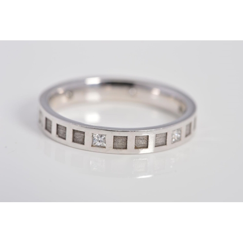 64 - A MODERN 18CT WHITE GOLD DIAMOND SET BAND, square cross section with square embossed panels and prin... 