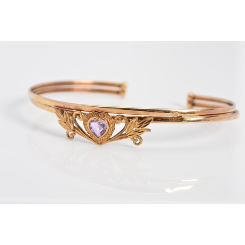 67 - A MODERN AMETHYST TORC BANGLE, centering on a heart shaped amethyst within a foliate surround, teste... 