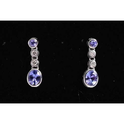 71 - A MODERN PAIR OF 18CT WHITE GOLD TANZANITE AND DIAMOND DROP EARRINGS, post and scroll fittings, meas... 