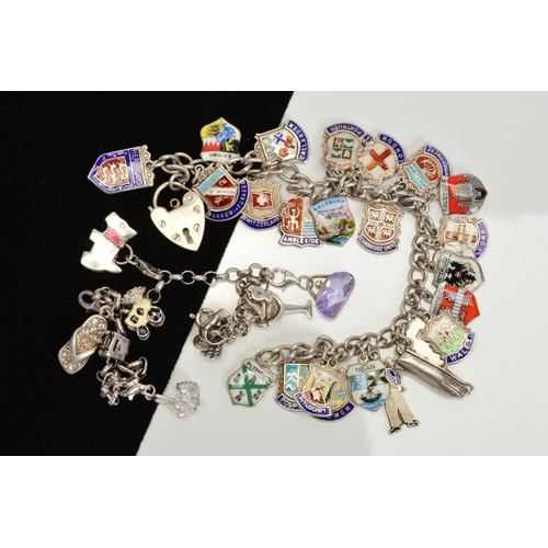 99 - TWO SILVER CHARM BRACELETS to include a curb link charm bracelet full of assorted enamelled shield c... 